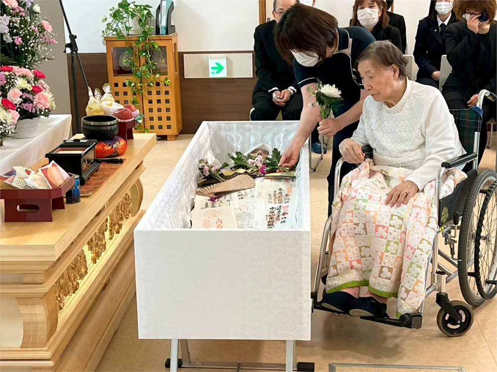 「最後の別れの儀」で花入れを行う利用者