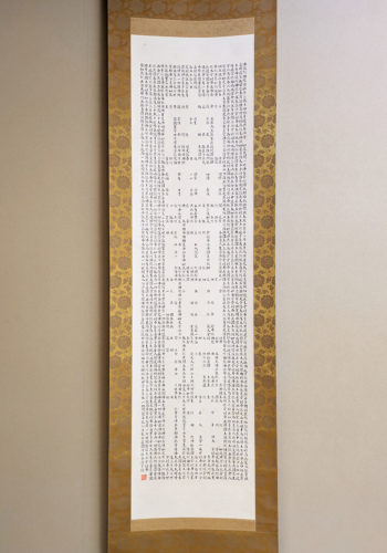 （画像阿弥陀経全体と部分の２枚：『阿弥陀経』を写して「南無阿彌陀佛」の六字名号を浮かび上がらせた西さんの書）