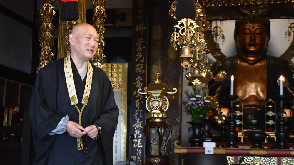 （画像アイキャッチ兼用：しばしの別れを告げる中村住職と修理される阿弥陀如来像）