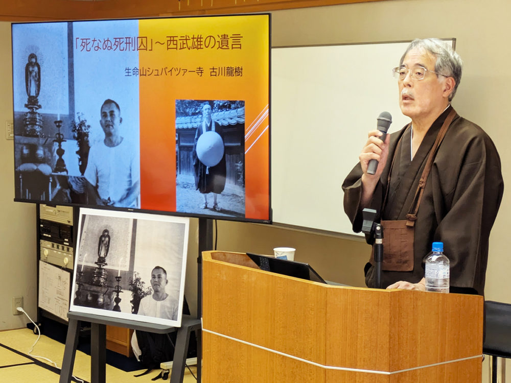 （画像アイキャッチ兼用：西武雄さんの写真とともに福岡事件について語る古川龍樹さん＝17日、京都府綾部市）