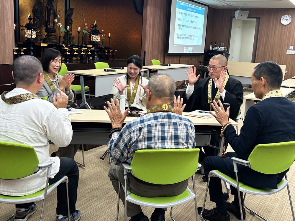 （画像アイキャッチ兼用：模擬カフェで、場をほぐす遊びを教える浄福寺の髙橋さん（左奥）。右奥は小川住職＝京都市東山区の源光院）