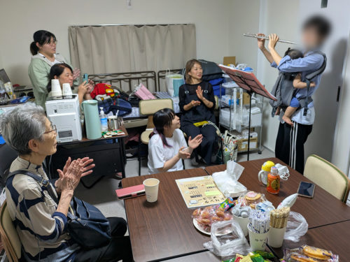 （画像：フルートの演奏に手拍子する参加者たち。演奏後、女性は「やっと来られた」と話した（画像を一部処理しています））