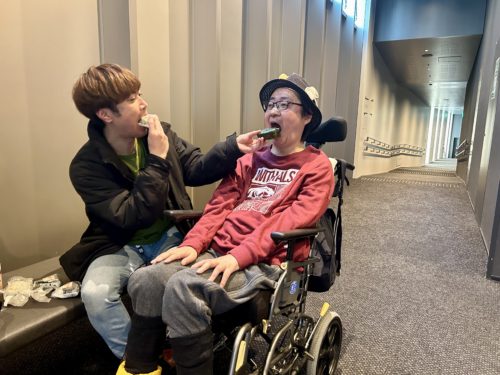 (画像2 おにぎりを頬張る2人)