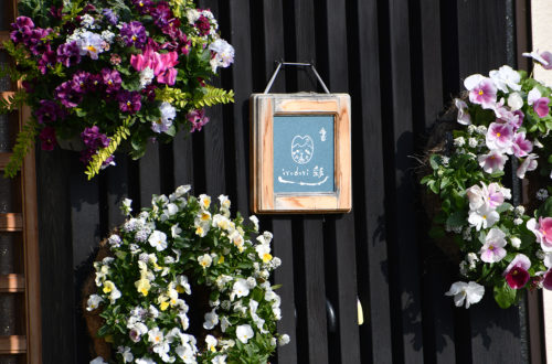 (画像1:自宅で開く書道教室の看板。「Irodori彩」と書かれ、花のリースで飾られている)