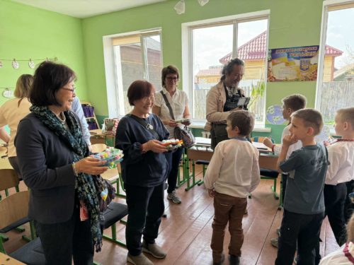 画像４）ウクライナの小学校で子どもたちに笑顔を向ける小林さん（前列左から２人目）