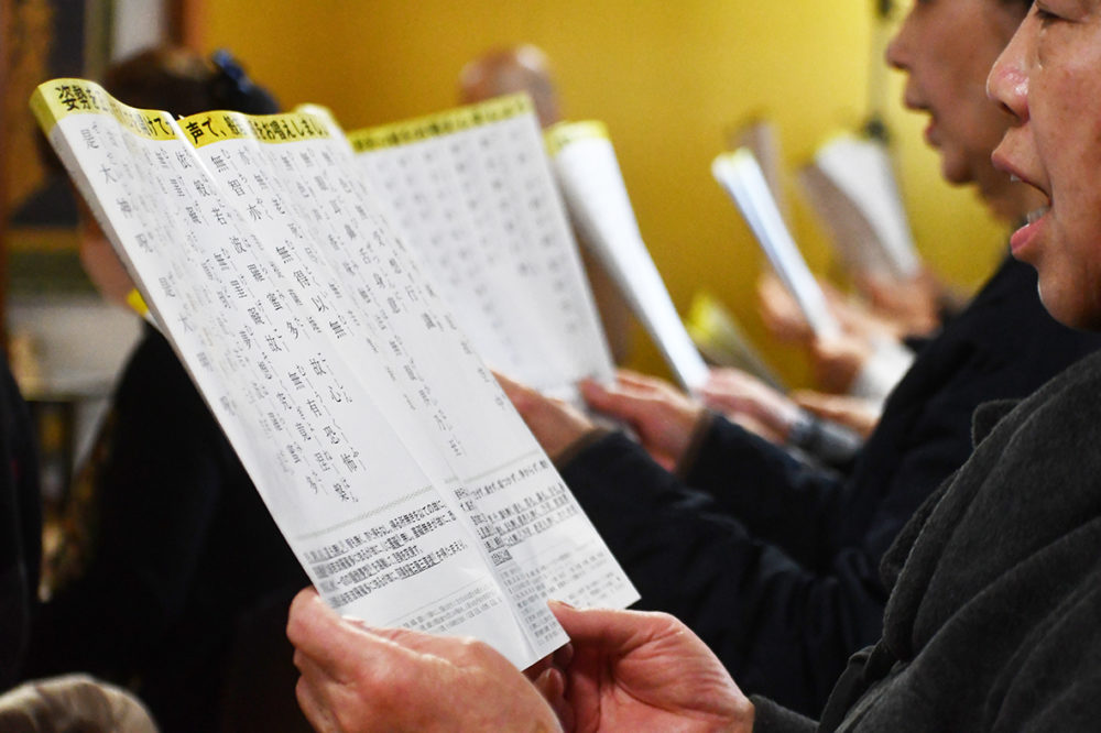 （画像３アイキャッチ兼用：背筋を伸ばして読経し、声を響かせる参加者たち）