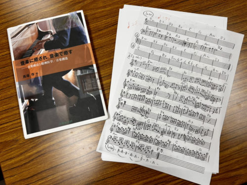 (画像2:著書『音楽に癒され、音楽で癒す』(左)と、手書きで書き起こした譜面)