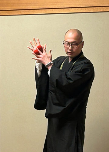 (画像:マジック説法を披露する井上さん)